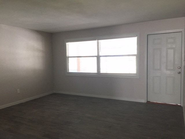 an empty room with a window and a door