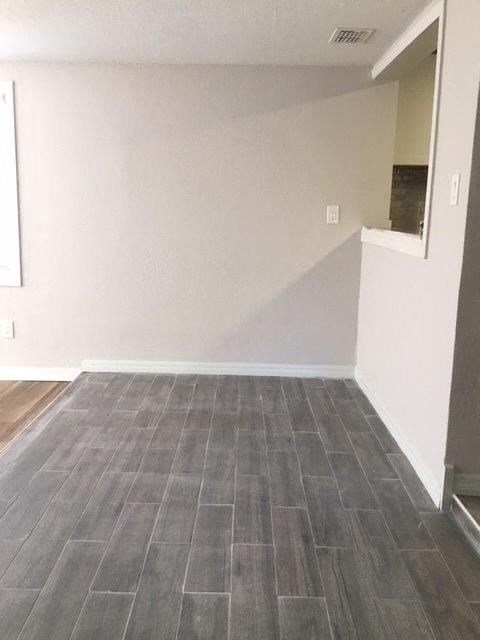 a empty room with a white wall and wooden floors