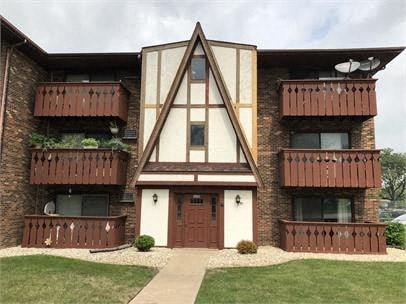 A brown and white building with a triangular design in the front.