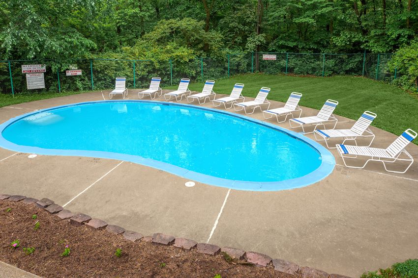 a swimming pool with chairs and chairs around it