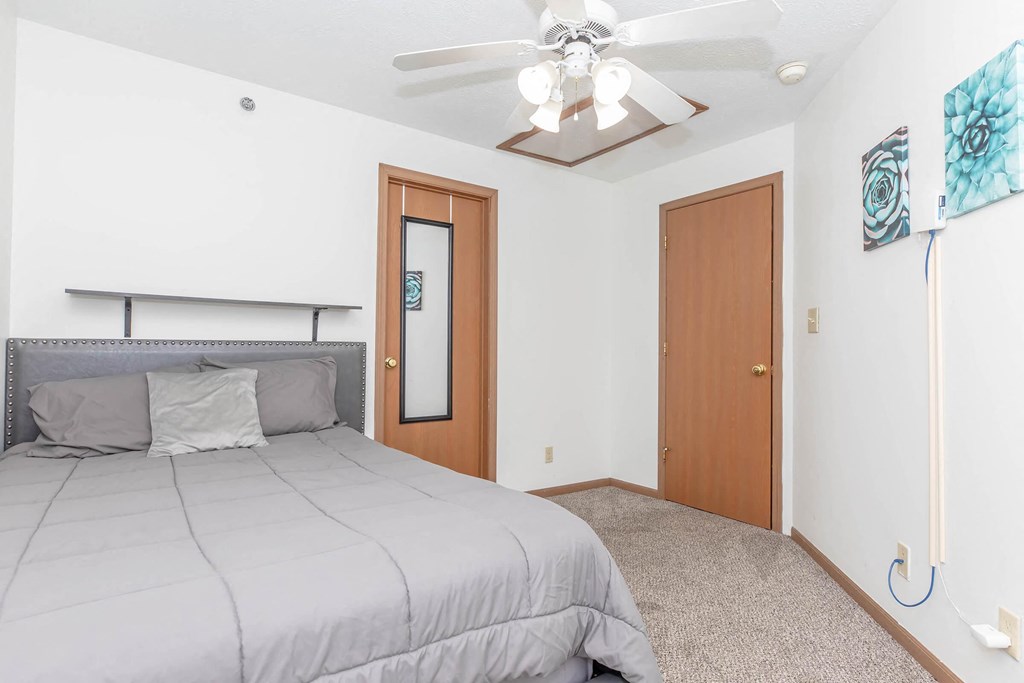 a bedroom with a large bed and a ceiling fan