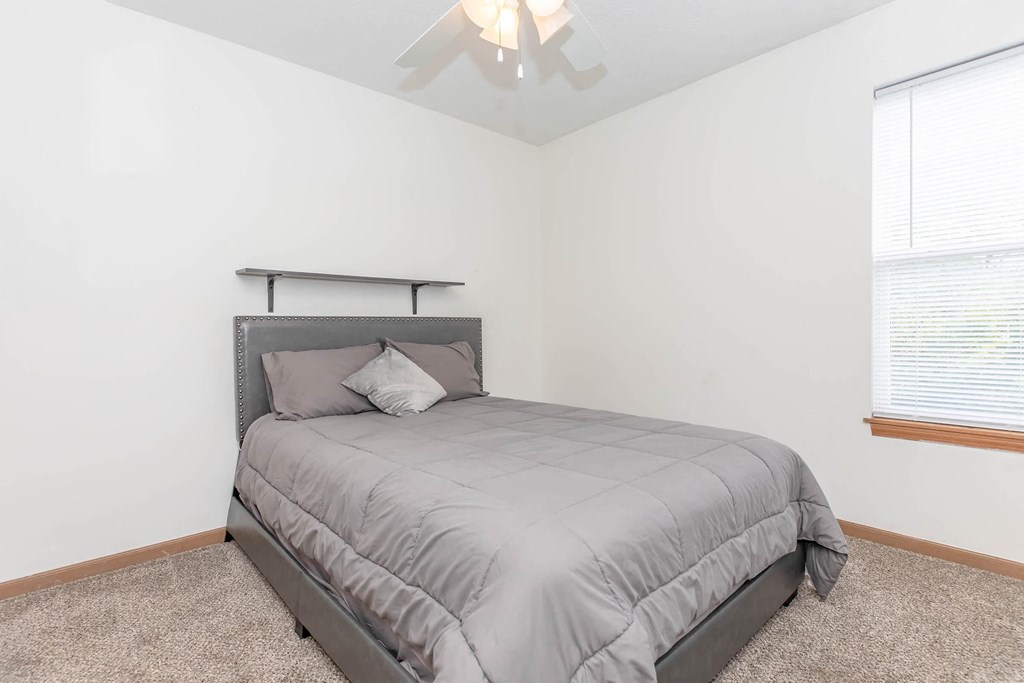 a bedroom with a bed and a ceiling fan