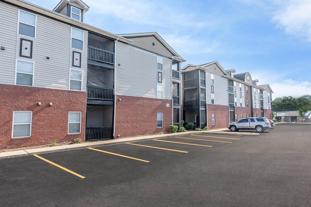 an empty parking lot in front of an apartment building