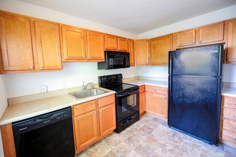 a kitchen with black appliances and wooden cabinets