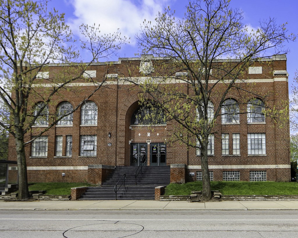 a large brick building with stairs in front of a street