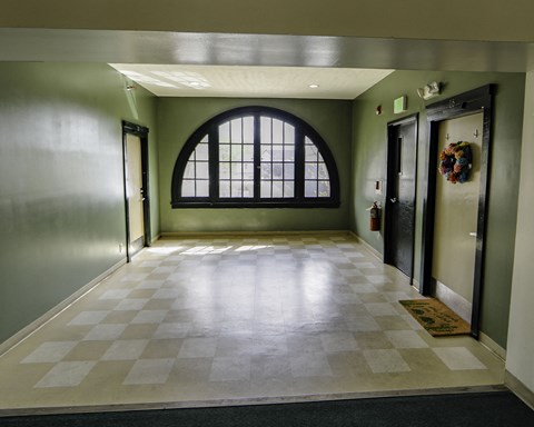 an empty hallway with a large window and doors