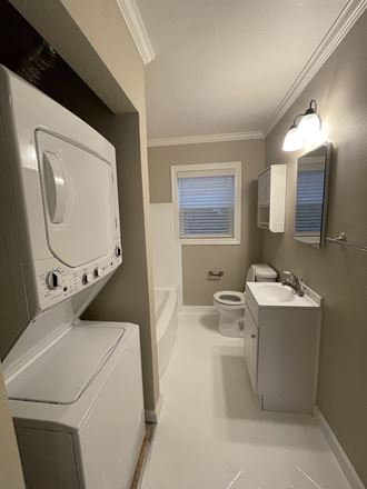 a bathroom with a washer and dryer and a toilet