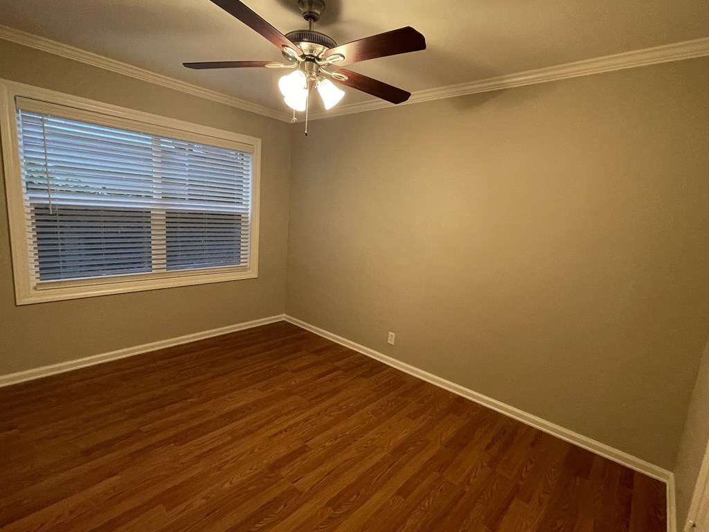 a living room with wood floors and a ceiling fan