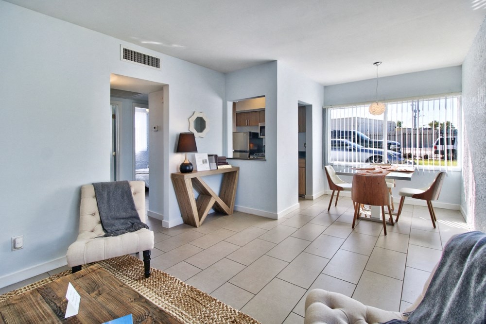 a living room and dining room with a table and chairs and a large window