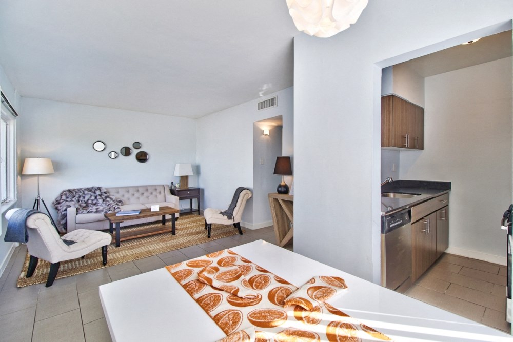 a living room with a couch and a table and a kitchen