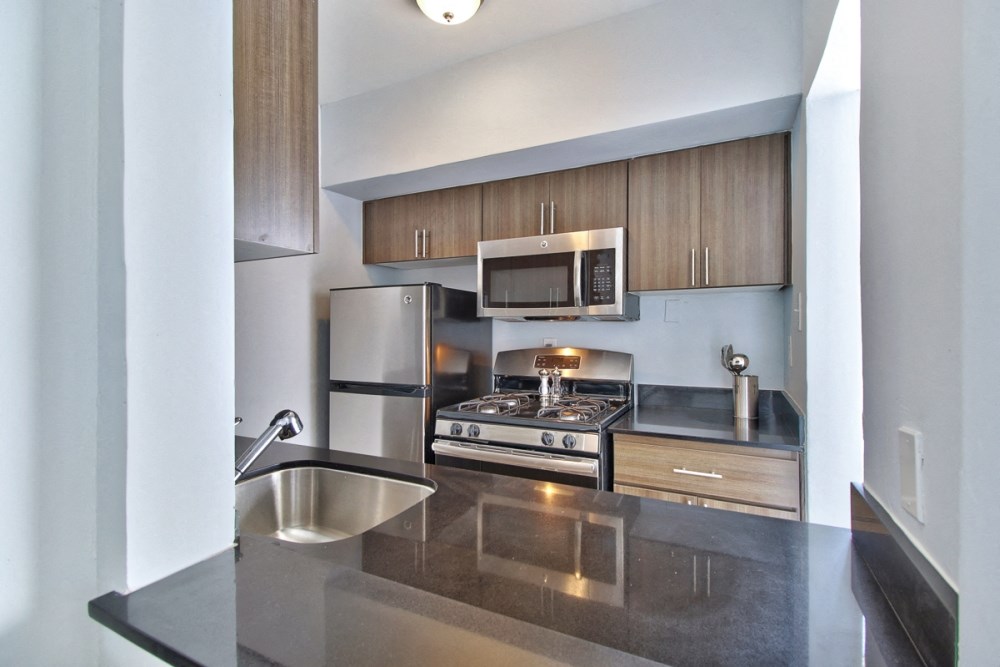 a modern kitchen with stainless steel appliances and wooden cabinets