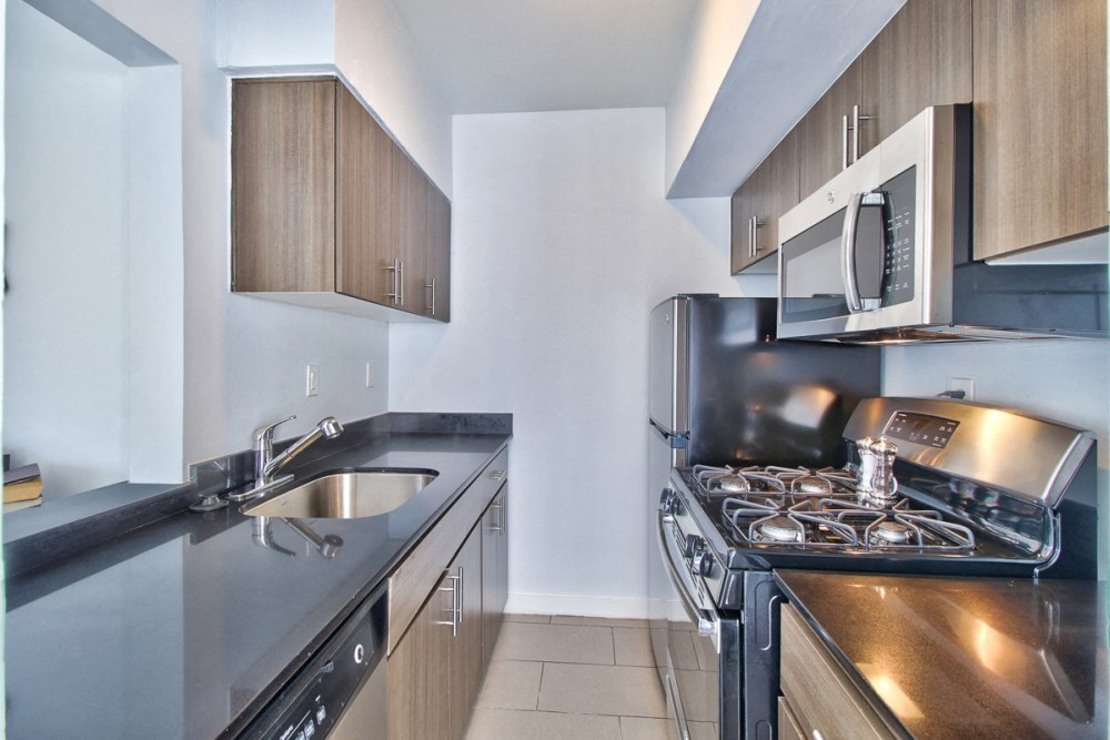 a kitchen with a stove and a sink and a microwave