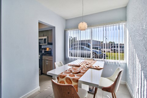 a dining room with a table and chairs and a large window