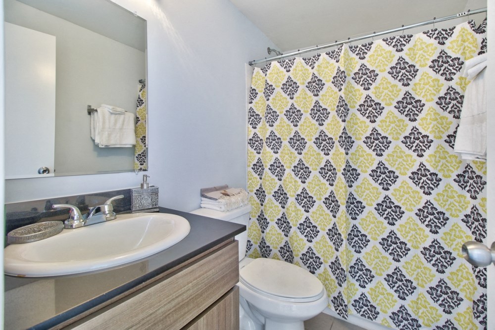 a bathroom with a shower and a sink and a toilet