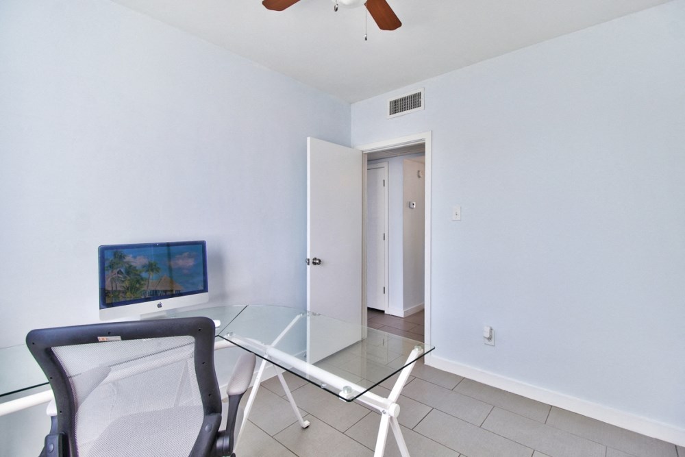 an empty room with a glass desk and a chair