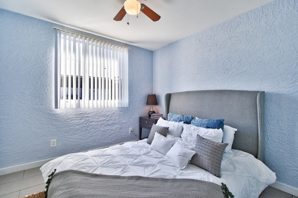 the master bedroom has a large bed and a ceiling fan