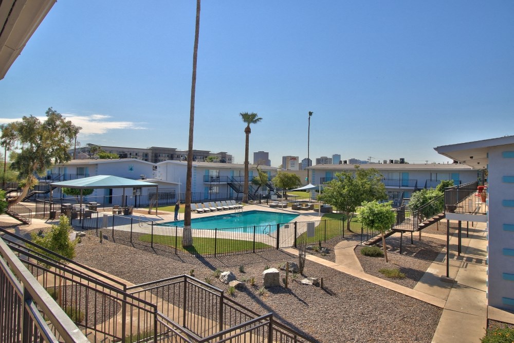 a resort style pool with trees and buildings in the background