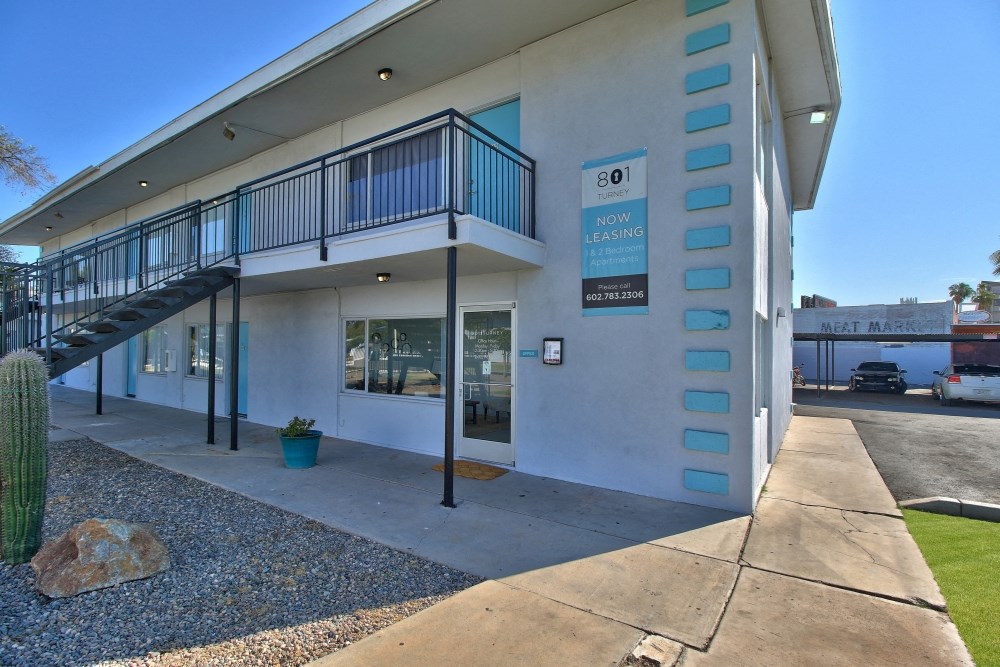 the front of a building with a staircase and a sidewalk