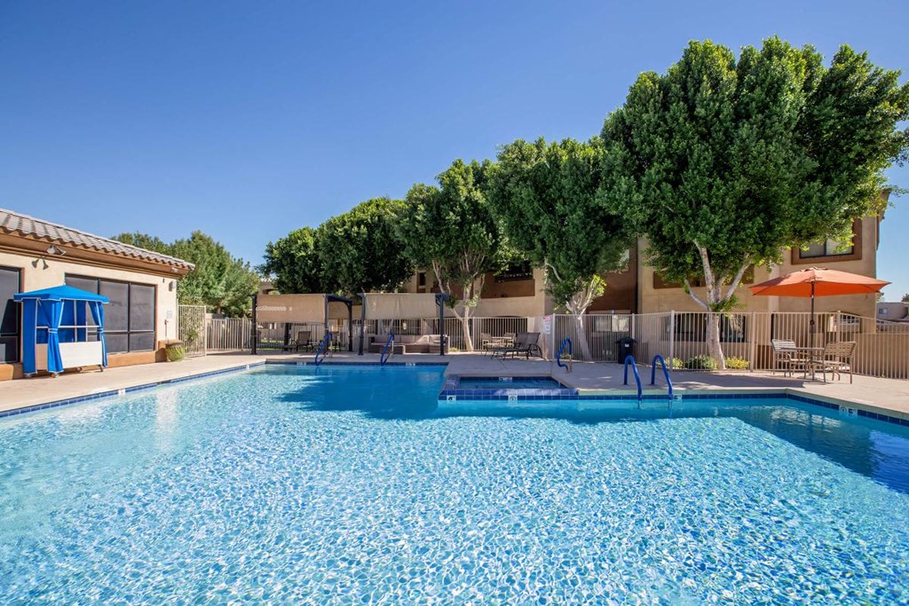 a swimming pool with trees and a building in the background