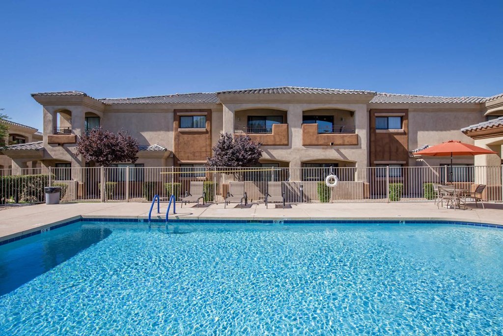 a large swimming pool in front of a resort style building