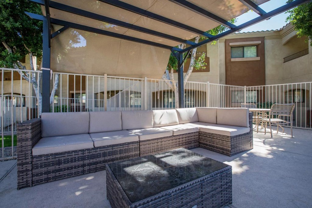 a patio with couches and a fire pit