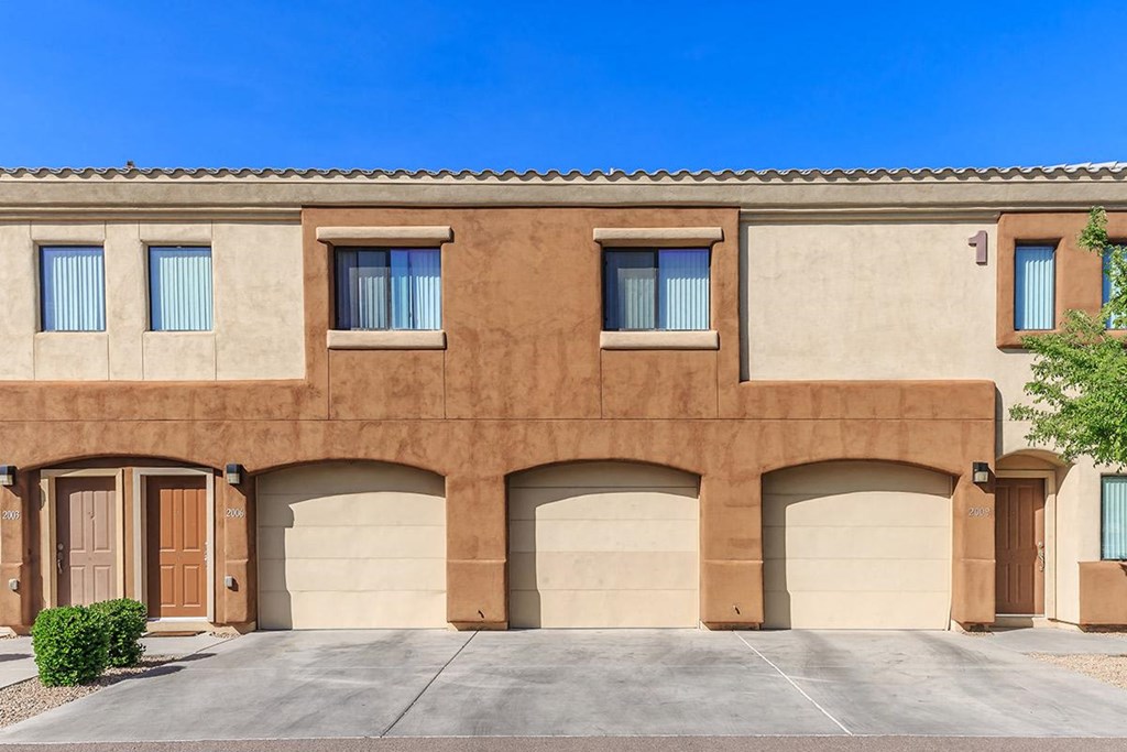 a brown building with three garage doors