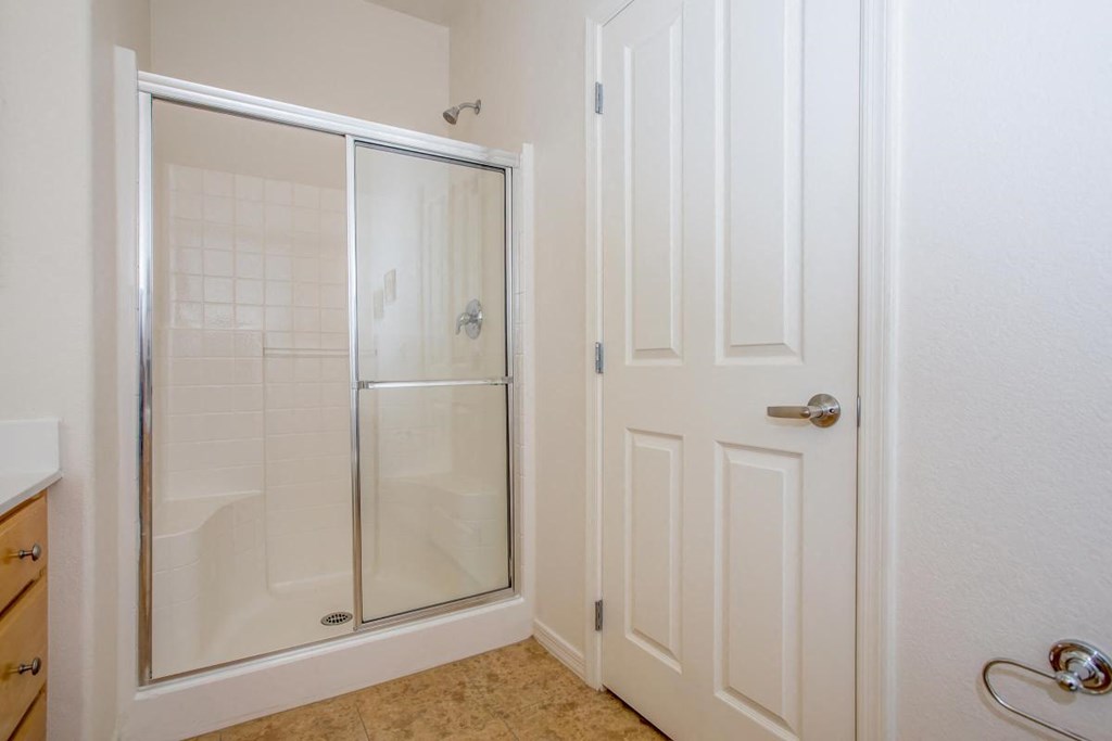 a bathroom with a shower and a white door