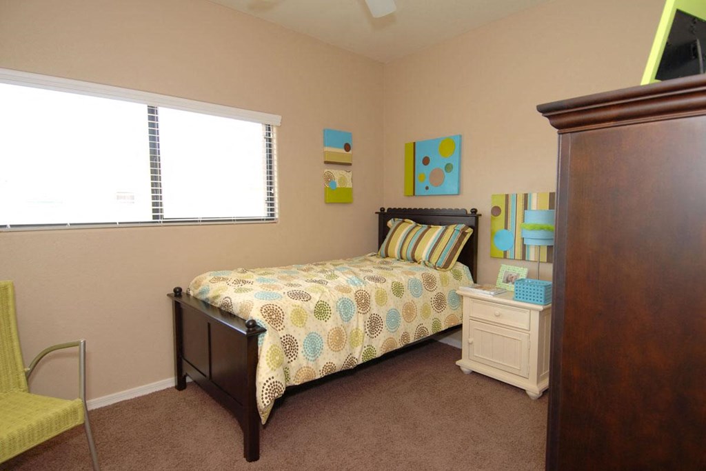 a bedroom with a bed and a dresser and a window