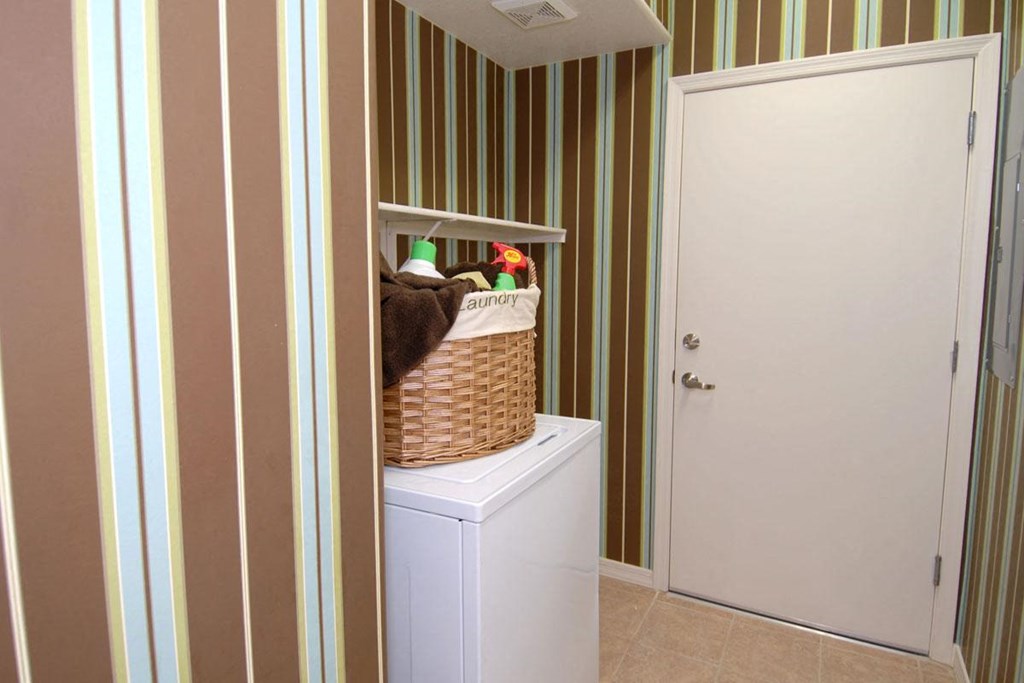 a laundry room with a basket on top of a washing machine