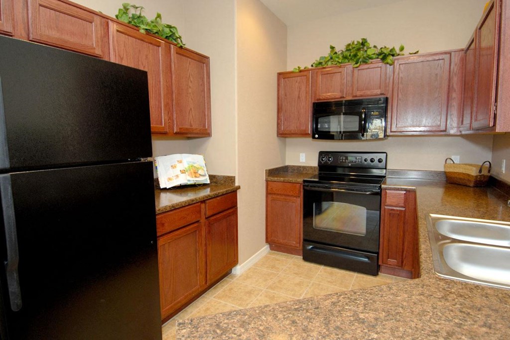 a kitchen with black appliances and wooden cabinets