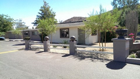 a white house with a fence and a parking lot