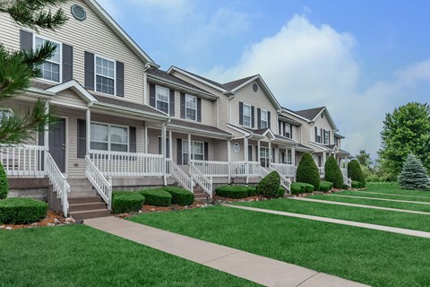A row of houses with green lawns in front.
