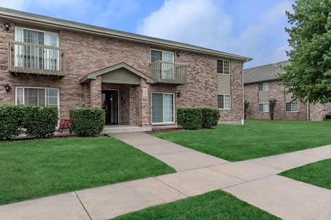 A brick building with a green lawn in front.