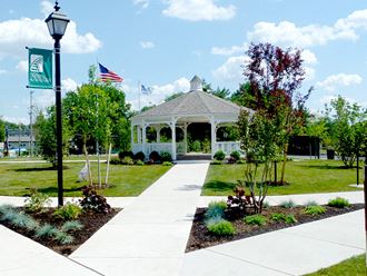 a white gazebo in a park with two flags
