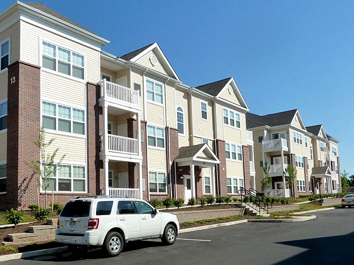 a white truck parked in front of a row of houses
