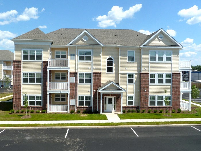 an exterior view of an apartment building with a parking lot