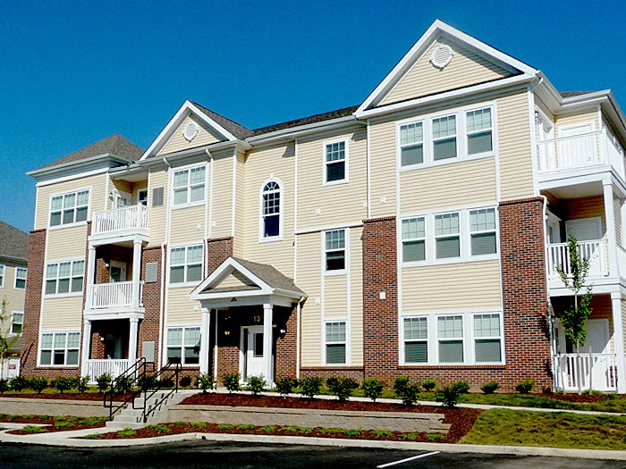 a large apartment building with brick and white siding