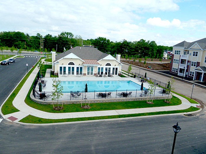 an aerial view of a swimming pool in front of a house