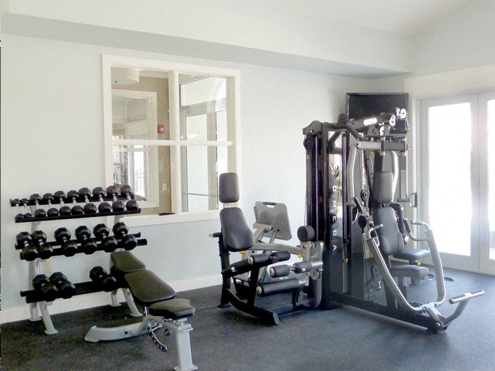 a gym with weights and mirrors in a home gym