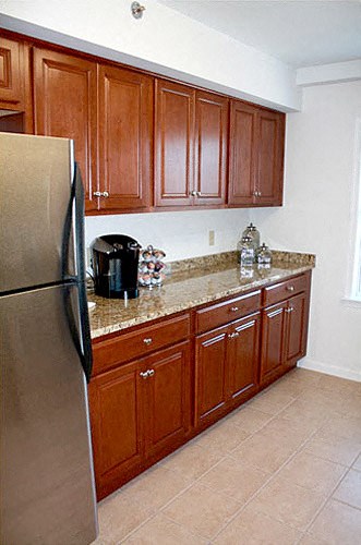 a kitchen with wooden cabinets and a stainless steel refrigerator