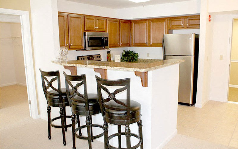 a kitchen with a bar with three stools