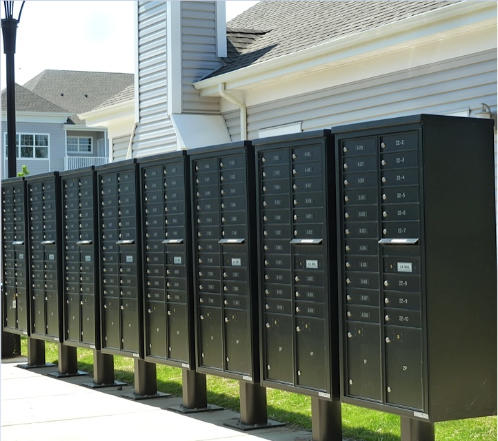 a row of green utility boxes in front of a house