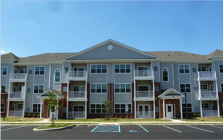 an apartment building with a parking lot in front of it