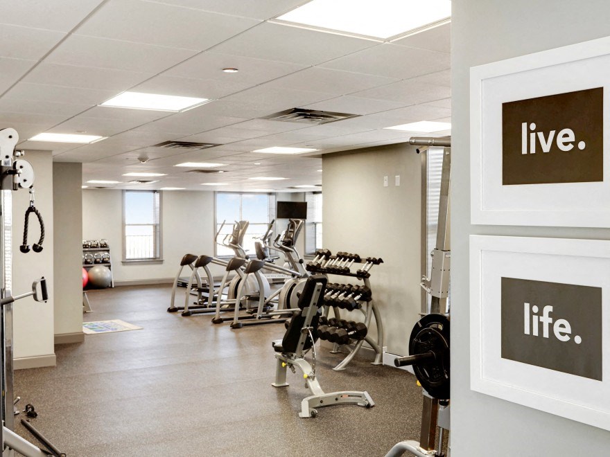 a gym with a lot of exercise equipment and a sign that says live
