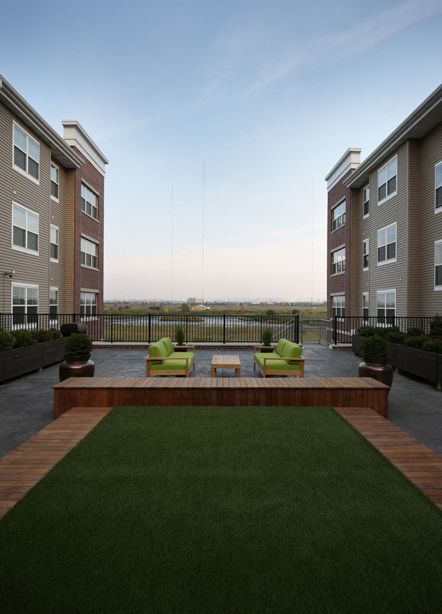 a rendering of an apartment complex with a lawn and a fire pit