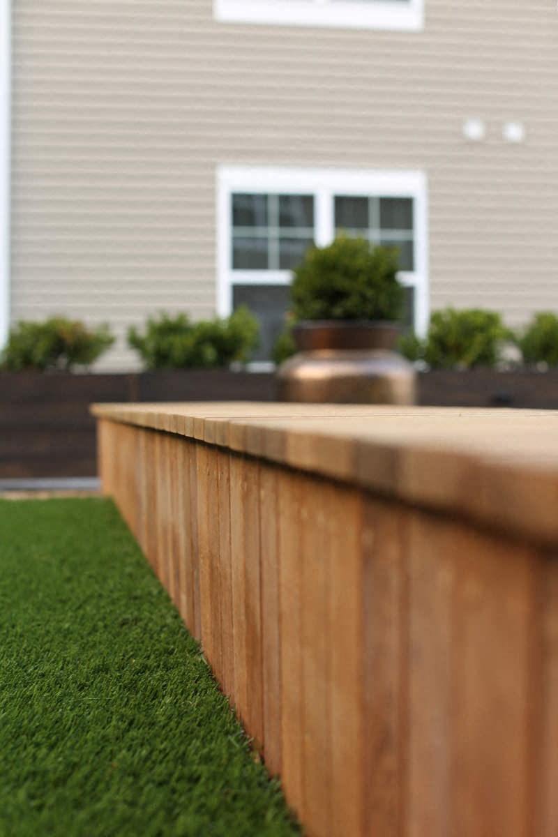 a wooden retaining wall in front of a house