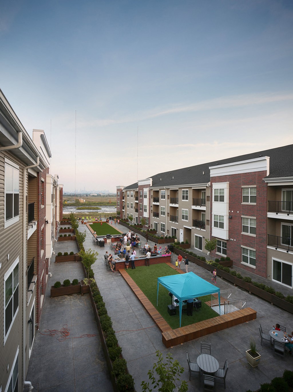 an aerial view of an apartment complex with tables and green grass