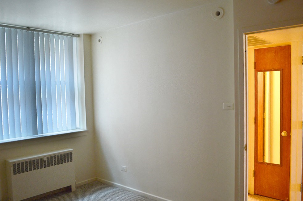 an empty room with a window and a door