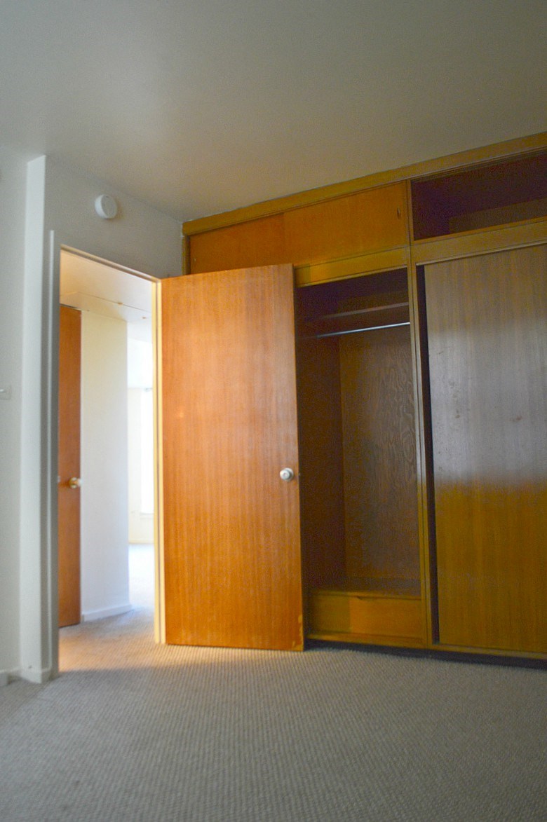 an empty room with a closet and a door