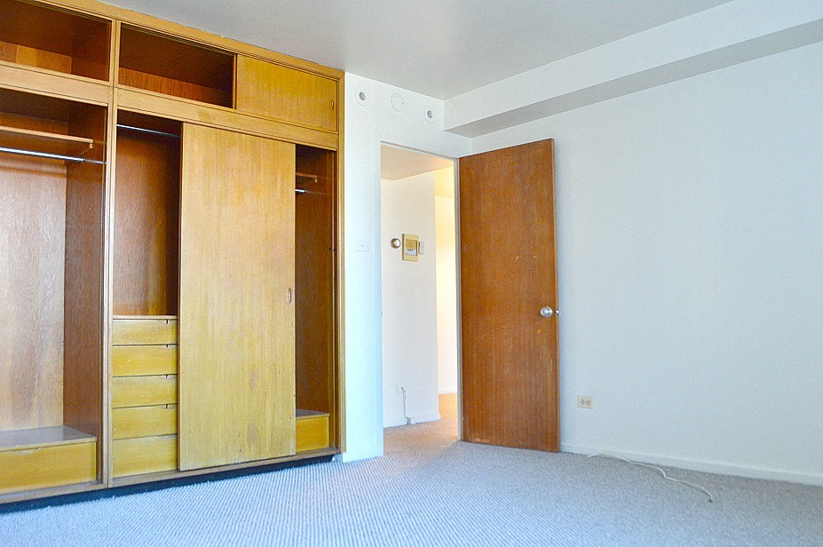 a bedroom with a wardrobe and a door to a bathroom